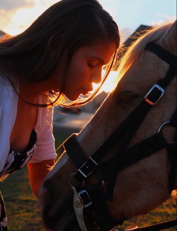 woman kissing horse's nose